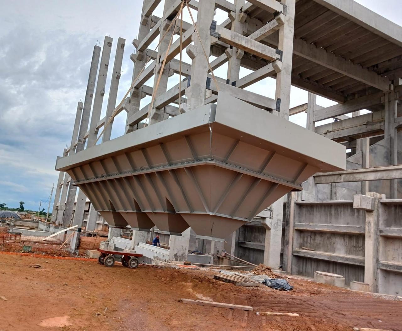 Moega metálica sendo içada para montagem na estrutura